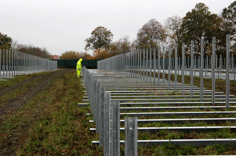 Etwas versteckt hinter Büschen und einem Sichtschutzzaun entsteht bei Boimstorf ein Solarpark. Der soll nicht nur Strom liefern.