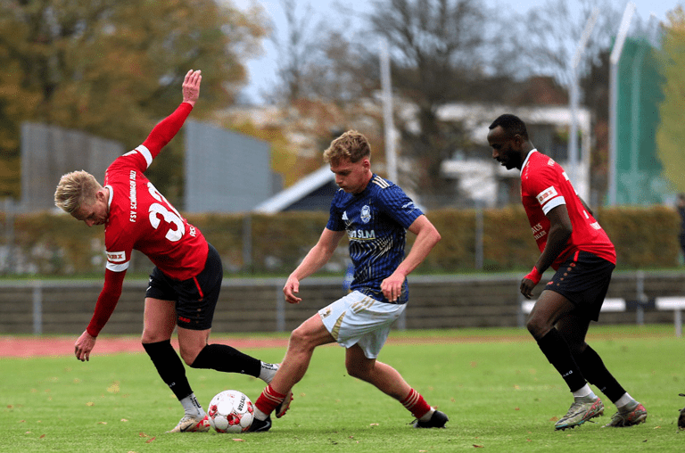 Willi Evseev (links) und Ousman Touray (rechts) haben im Zweikampf mit einem Phönix-Akteur das Nachsehen